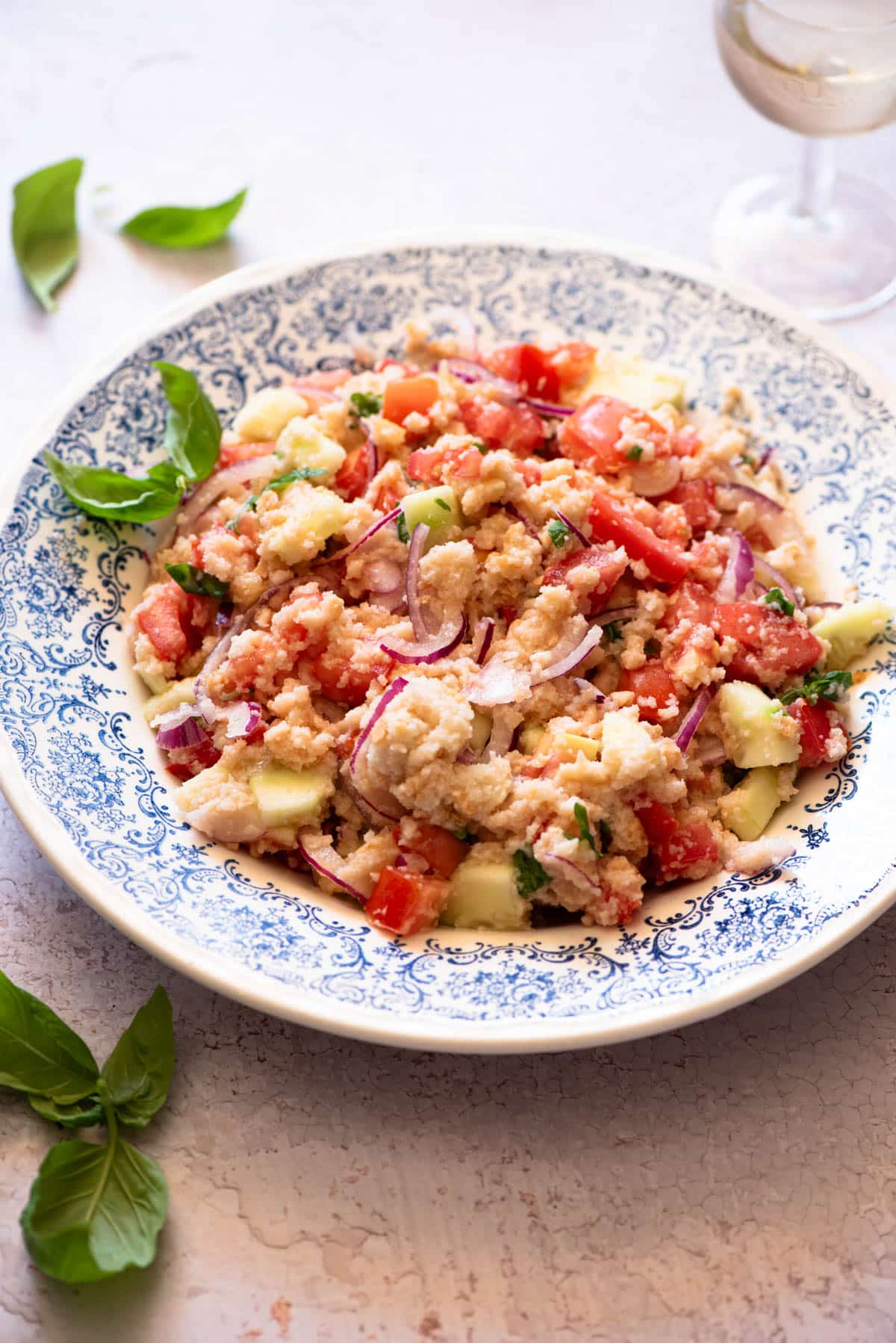 A close up of a Panzanella salad in a blue bowl.