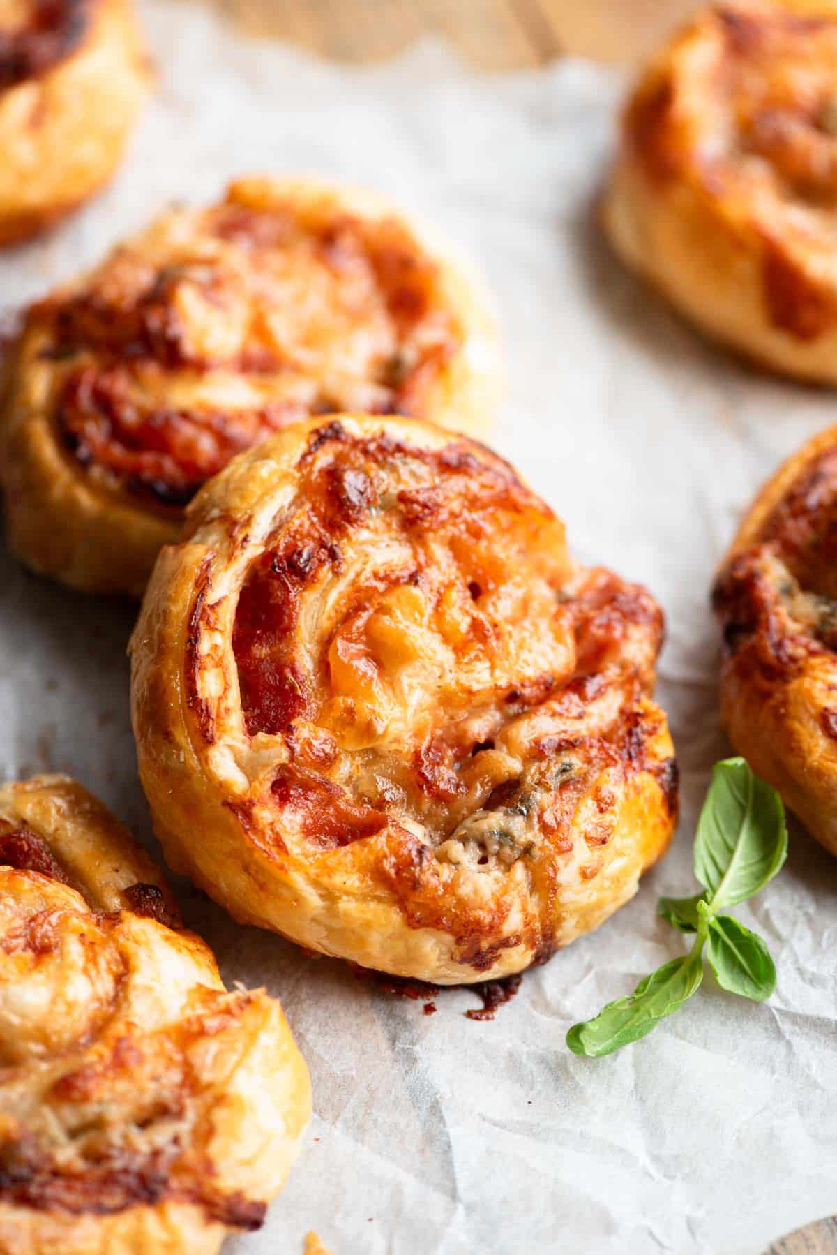 A close up of pizza pinwheels on a wooden board.