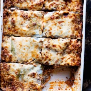 An overhead shot of lasagna cut into slices in a baking dish.