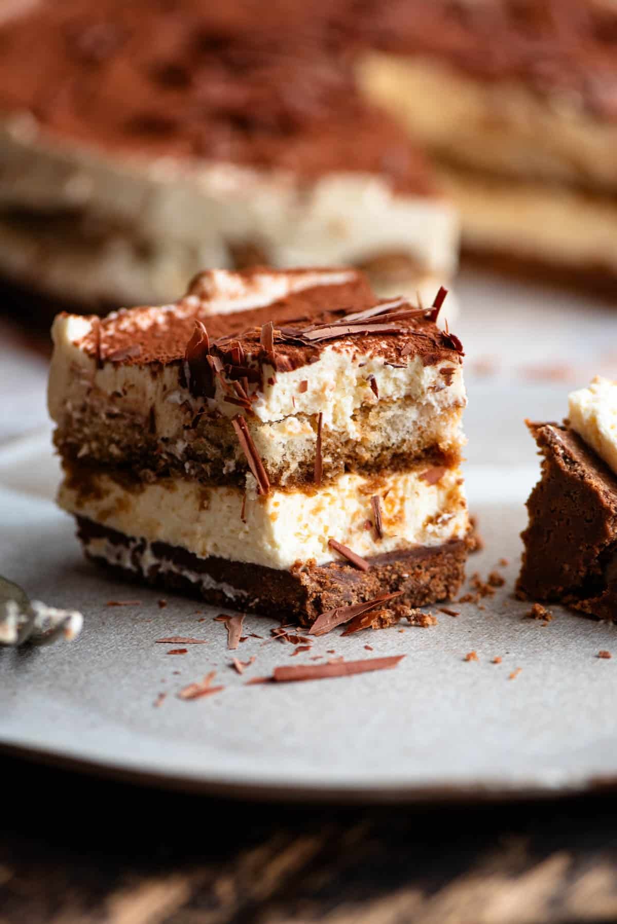 A close up of a slice of tiramisu cheesecake with a bite out.