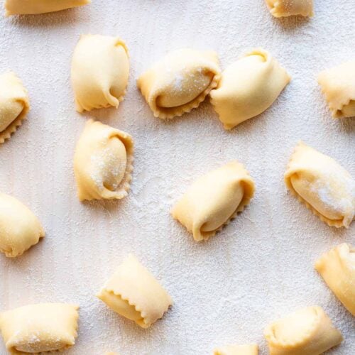 An overhead shot of Agnolotti pasta on a wooden board.