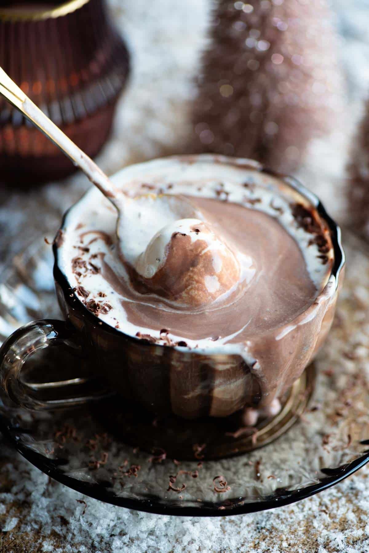 A close up of a hot chocolate affogato and a spoon scooping up some ice cream and chocolate.