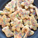 A close up cropped image of Befanini cookies on a plate the coloured fairy lights around.