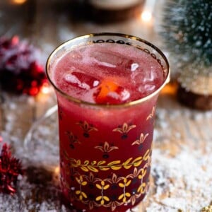 A close up of a Christmas Cocktail made of Cranberry juice and Prosecco in a gold glass.