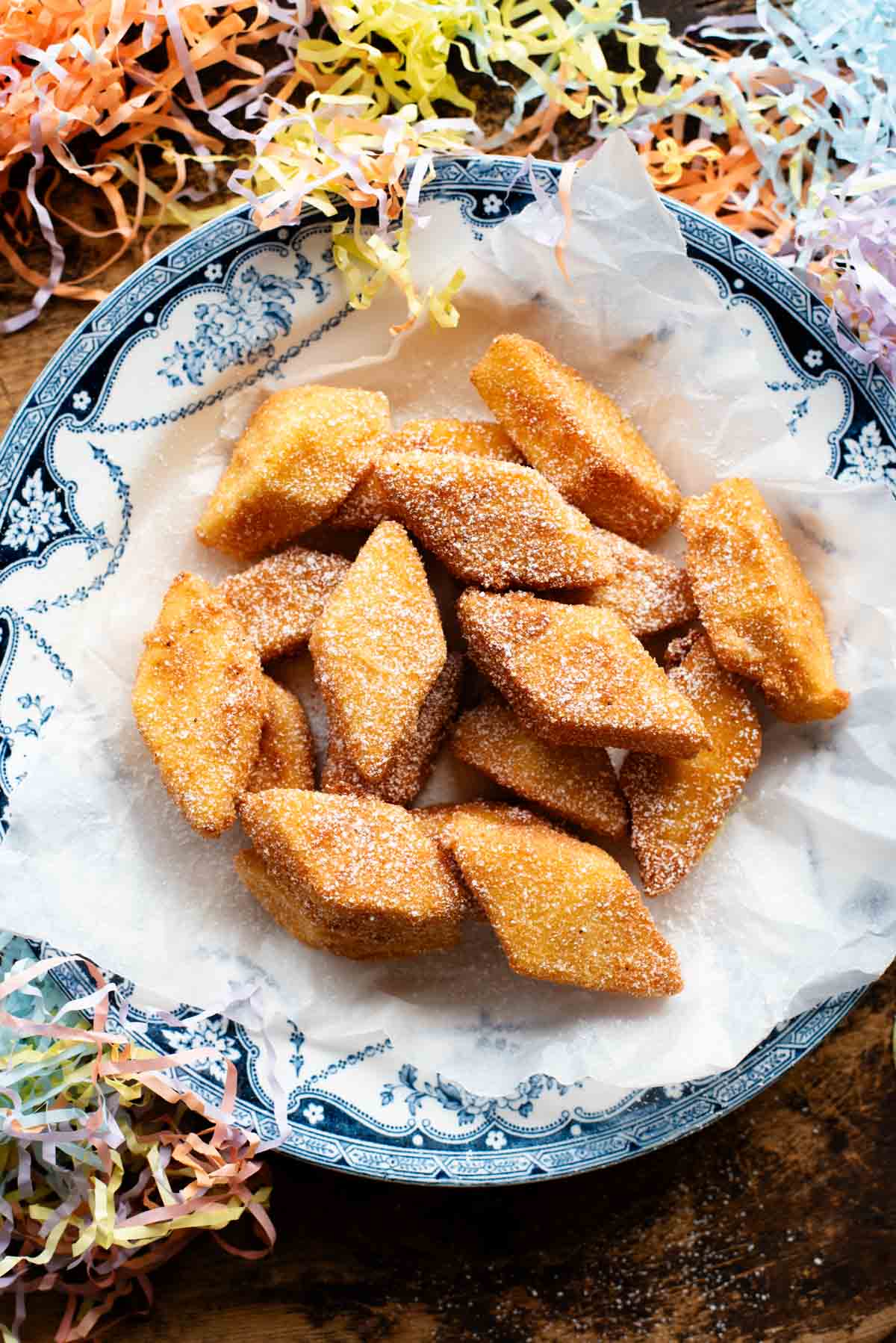 Deep fried custard in a blue bowl on a wooden surface.