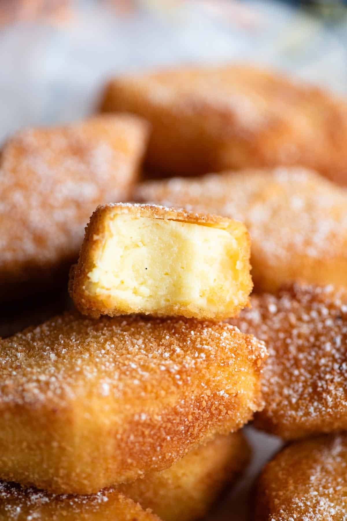 A close up of Crema Fritta (deep fried custard) cut in half showing the inside.