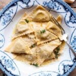 A cropped image of triangoli pasta in a blue patterned bowl.