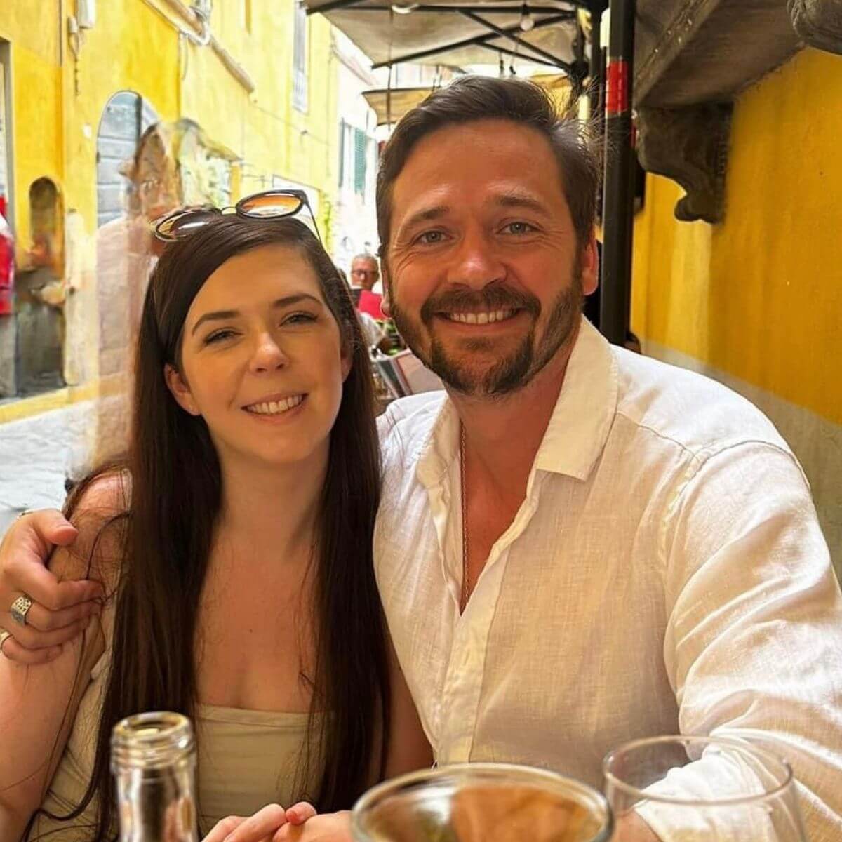 Emily and Nathan sitting at a table in a restaurant smiling at the camera for a photo.