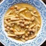 An overhead shot of pasta and chickpeas (pasta e ceci) in a blue bowl.