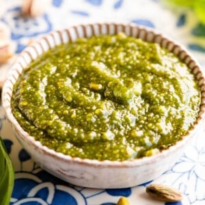 A close up cropped image of pistachio pesto in a small dish.