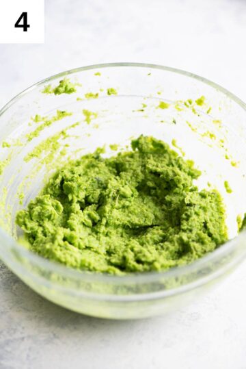 Pea pesto blitzed to a smooth paste in a small glass bowl.