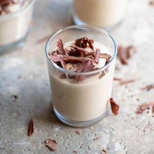 A close up of coffee ricotta cream (ricotta al caffe) in a small glass.