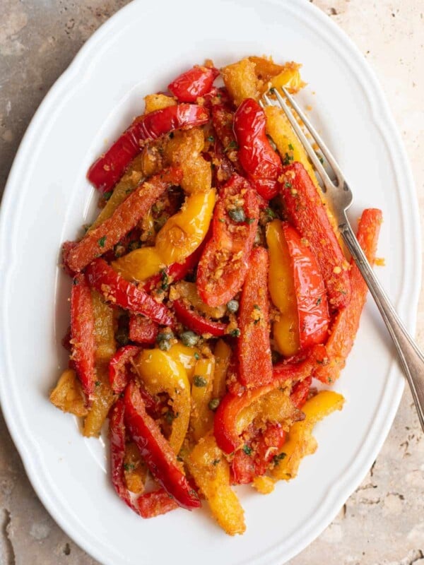 An overhead shot of Peperoni Ammollicati (Italian peppers and breadcrumbs) on a white serving plate.