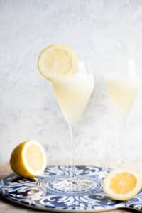A Sgroppino cocktail in a flute glass with a slice of lemon on the side.