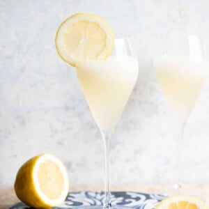 A Sgroppino cocktail in a flute glass with a slice of lemon on the side.