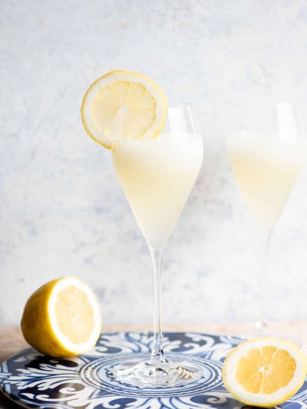 A Sgroppino cocktail in a flute glass with a slice of lemon on the side.