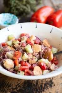 Cialledda salad in a white bowl sitting on a wooden surface.