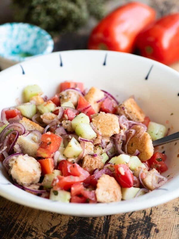Cialledda salad in a white bowl sitting on a wooden surface.