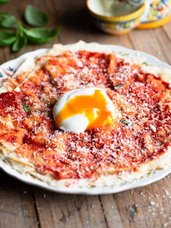Pane Frattau on a plate (tomato and bread) topped with a poached egg.