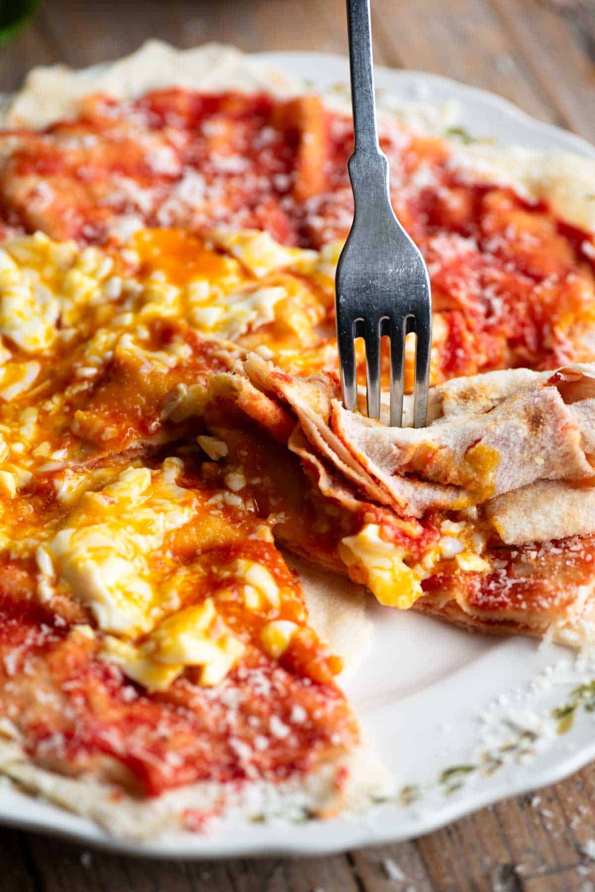 A fork cutting into a piece of pane frattau.