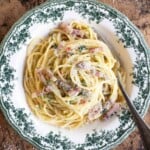 A close up cropped image on Spaghetti alla Molisana with pancetta, onion and chilli in a green patterned bowl.