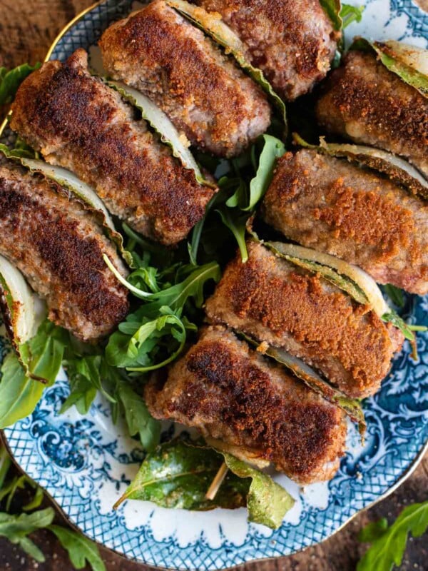 An overhead shot of Sicilian involtini on skewers with breadcrumbs.