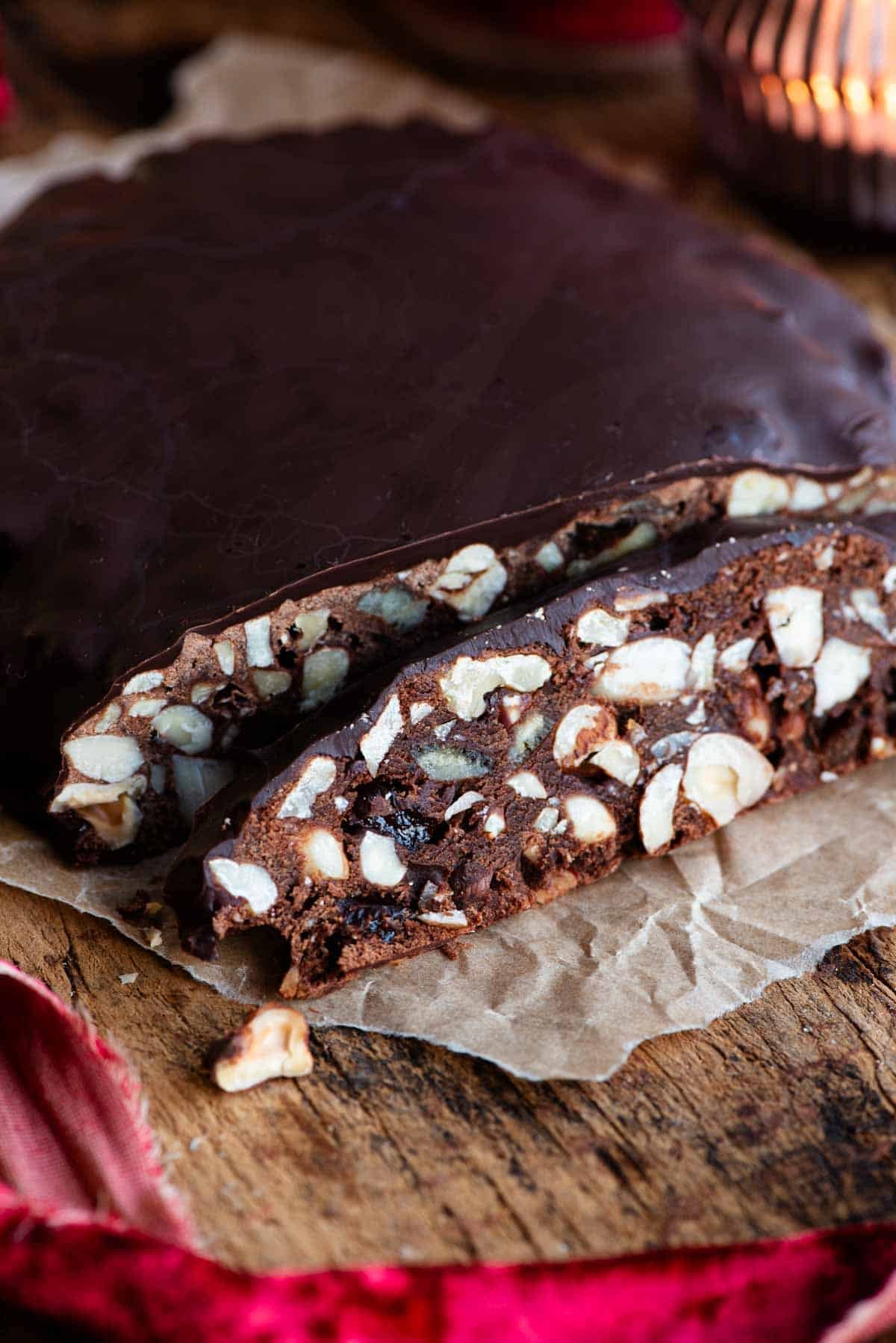 A close up of a slice of Panpepato filled with nuts and dried fruit.
