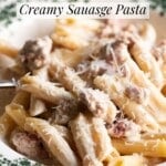 A close up of creamy sausage and truffle pasta in a green bowl with a fork.