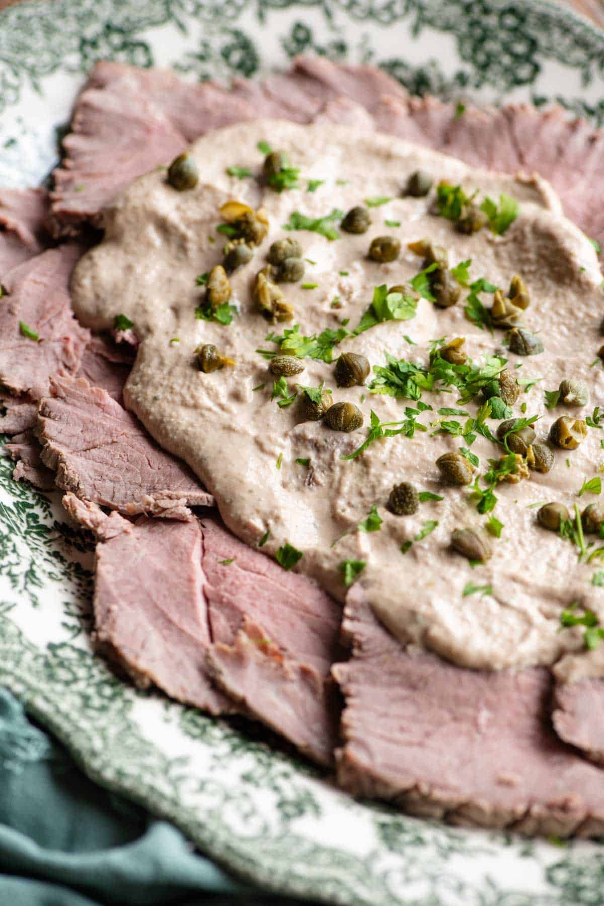 A close up of Vitello Tonnato on a serving dish.