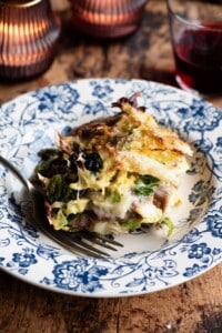 A slice of a rustic Italian casserole on a blue plate.