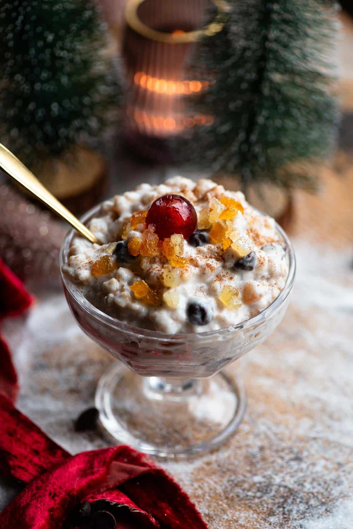 A Sicilian dessert made with ricotta, grain and candied fruit in a glass serving dish topped with a candied cherry.