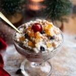 A close up of Cuccia, a Sicilian ricotta dessert in a small glass bowl topped with candied fruit.