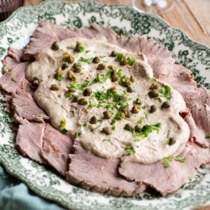 A cropped image of vitello tonnato on a serving platter.