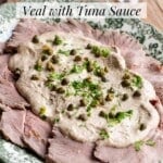 Slices of veal on a serving platter served with a tuna sauce, capers and parsley.