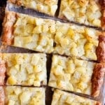 A cropped overhead image of a puff pastry potato tart cut into slices.