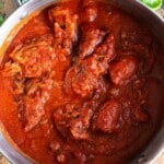 A square cropped image of ragu alla napoletana in a large pot.
