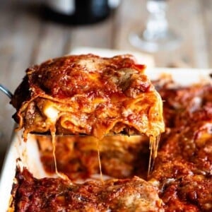 A cropped close up image of a slice of Neapolitan lasagna.