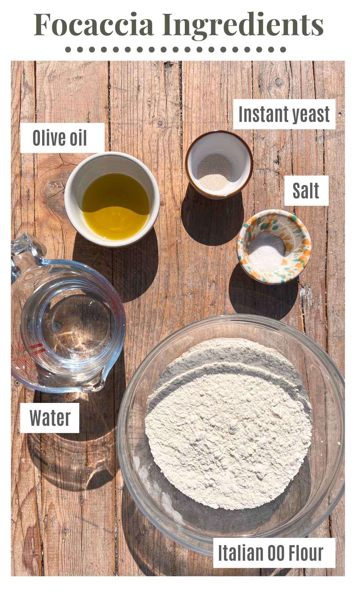 All the ingredients needed to make a focaccia laid out on a rustic wooden surface.