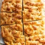 Golden, rustic and bubbly focaccia cut into 8 slices.