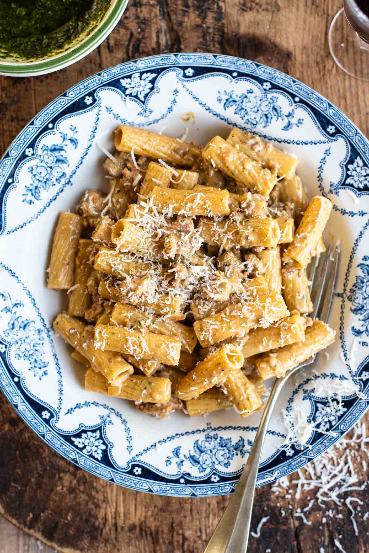 Pasta alla Montecarlo (creamy meat sauce) in a country style blue and white bowl sitting on a wooden chopping board.
