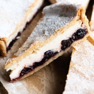 A close up of a a slice of ricotta and cherry tart.