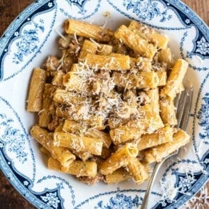 Pasta alla Montecarlo in a blue and white bowl topped with Parmigiano Reggiano.