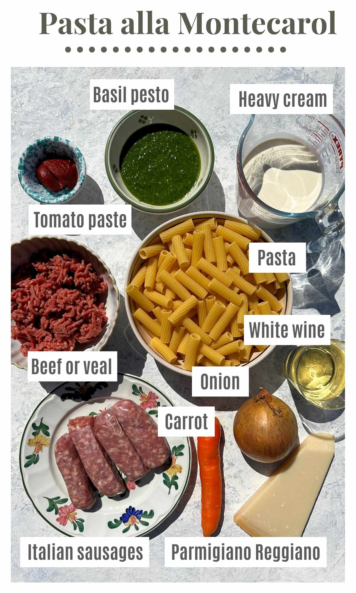 An overhead shot of all the ingredients needed to make Pasta alla Montecarlo; pesto, heavy cream, tomato paste, pasta, sausages, beef, carrot, onion, Parmesan and white wine.