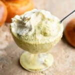 A close up of pistachio granita in a glass bowl with whipped cream on top.