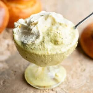 A close up of pistachio granita in a glass bowl with whipped cream on top.