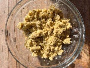 pastry dough in a rough crumb texture in a glass bowl.