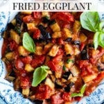A close up of fried eggplant in tomato sauce in a blue and white vintage bowl. The text overlay reads: Southern Italian Fried Eggplant.