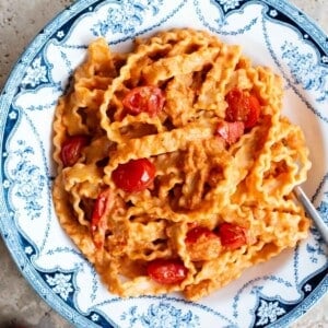 Pasta ribbons in a creamy sundried tomato sauce in a blue and white bowl.