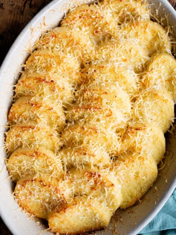 A close up of Gnocchi alla Romana in a baking dish topped with Parmigiano cheese.
