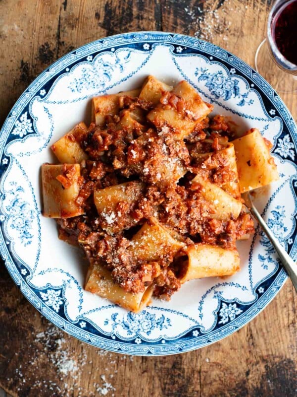 A blue and white vintage style bowl with paccheri and hazelnut ragu.
